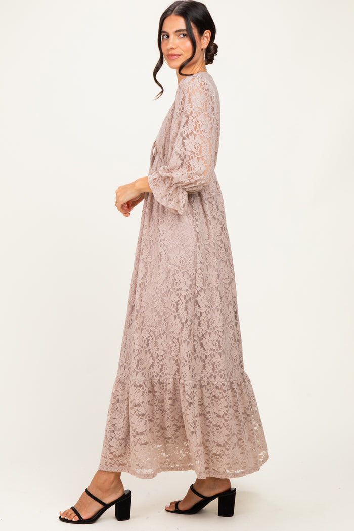 woman wearing a light taupe lace maxi dress with bell sleeves and tiered design, styled with black block heel sandals
