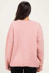 woman wearing a soft pink oversized sweater with a textured finish, viewed from the back