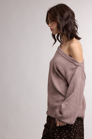 woman wearing a dusty rose off-the-shoulder oversized sweater with a relaxed fit and ribbed neckline