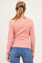 woman wearing a pink and white striped maternity long sleeve top, seen from the back with a ponytail hairstyle