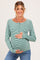 woman wearing a green and white striped maternity top with buttons, showcasing her baby bump