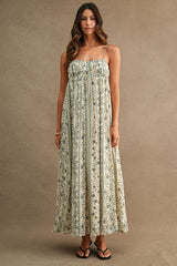 woman wearing a floral maxi dress with spaghetti straps and a flowy silhouette