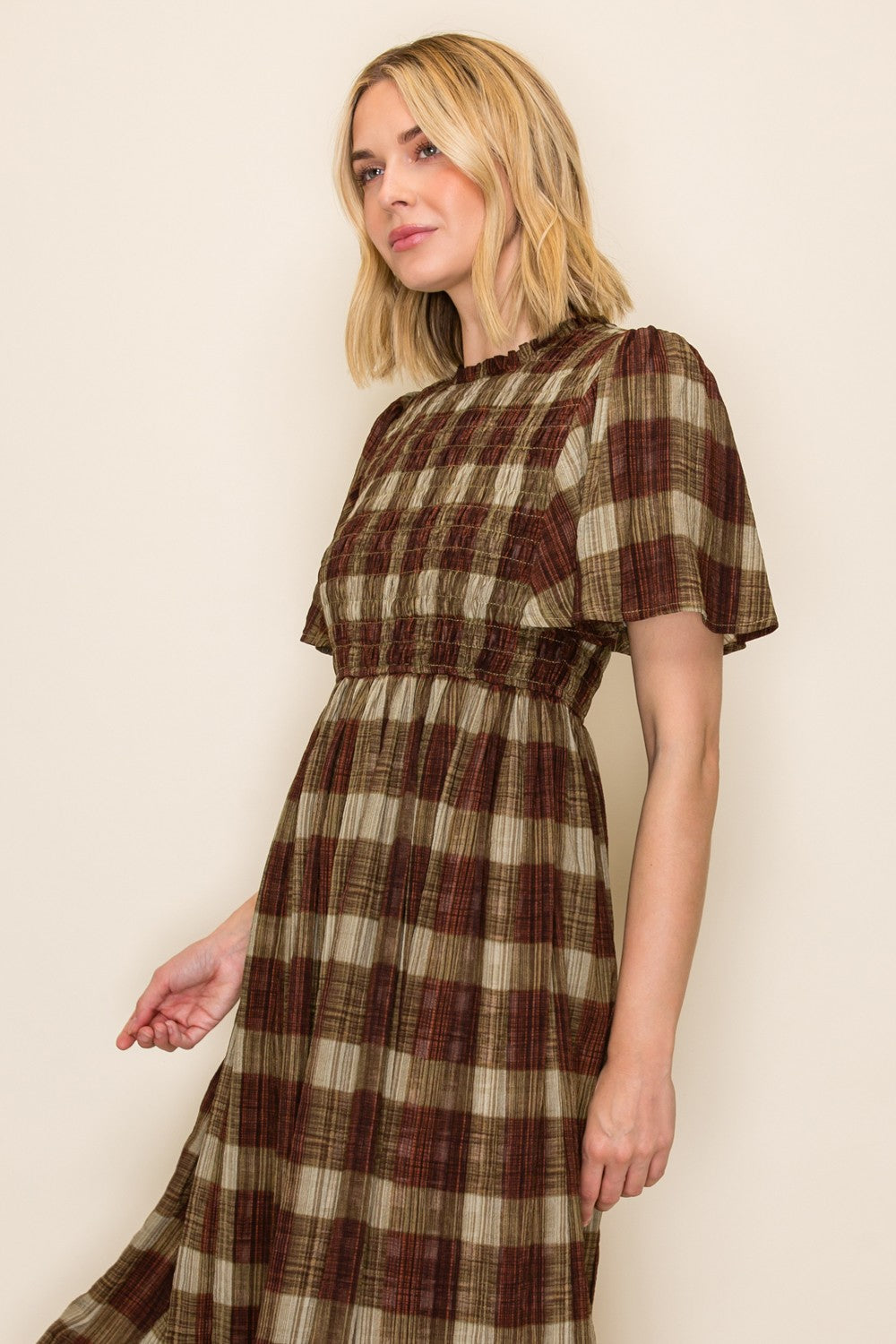 woman wearing a brown and green plaid maxi dress with short sleeves and a smocked waist