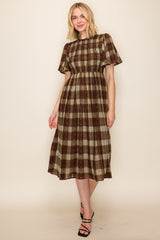 woman wearing a brown and beige plaid midi dress with short ruffle sleeves and smocked bodice