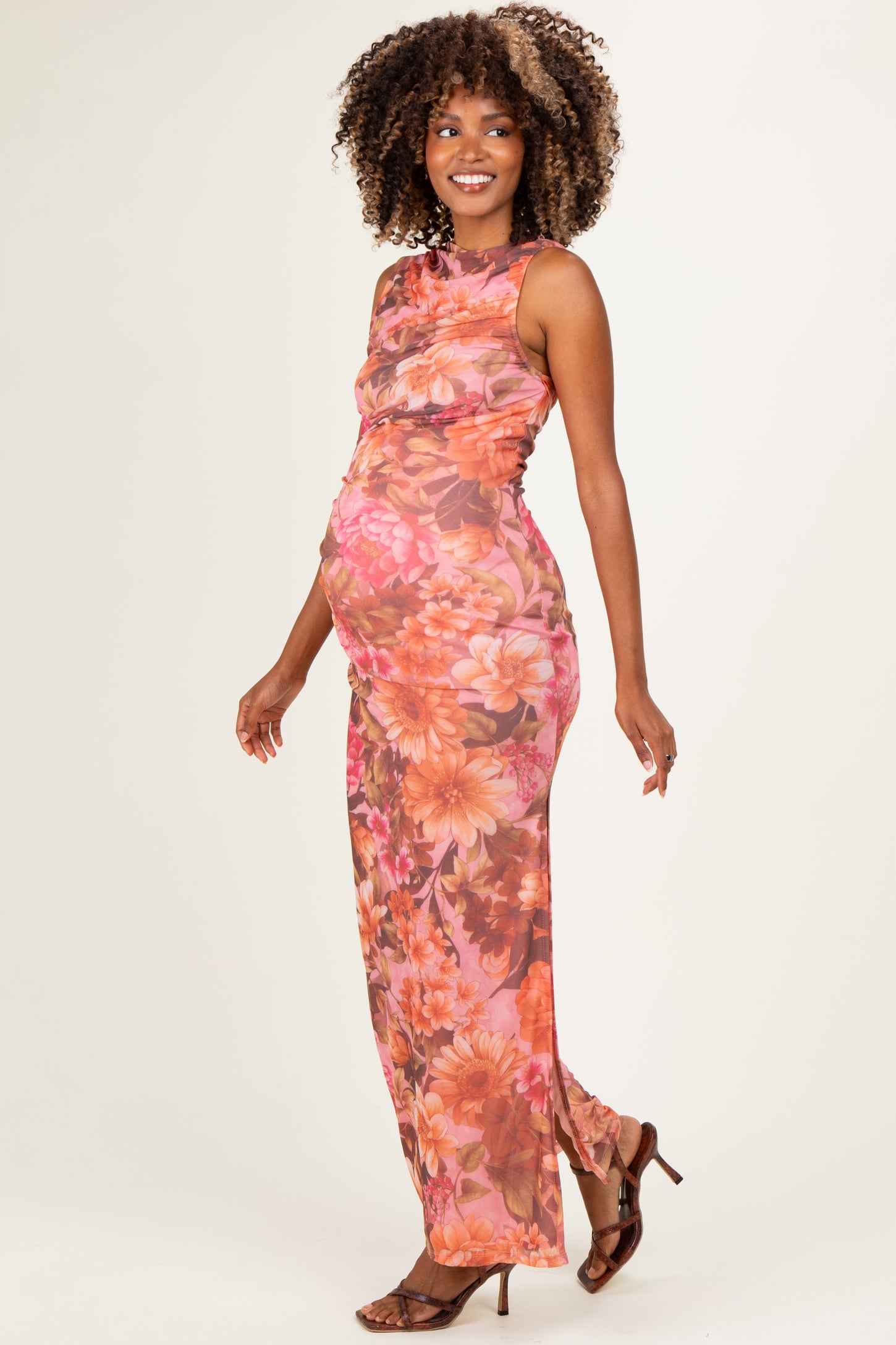 woman wearing a floral print maternity maxi dress with a fitted silhouette and a visible baby bump