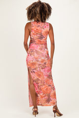 woman wearing a floral maternity maxi dress with a side split, showing a fitted silhouette and a back view
