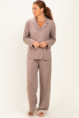woman wearing a taupe long sleeve pajama set with white piping details and matching loose-fit pants