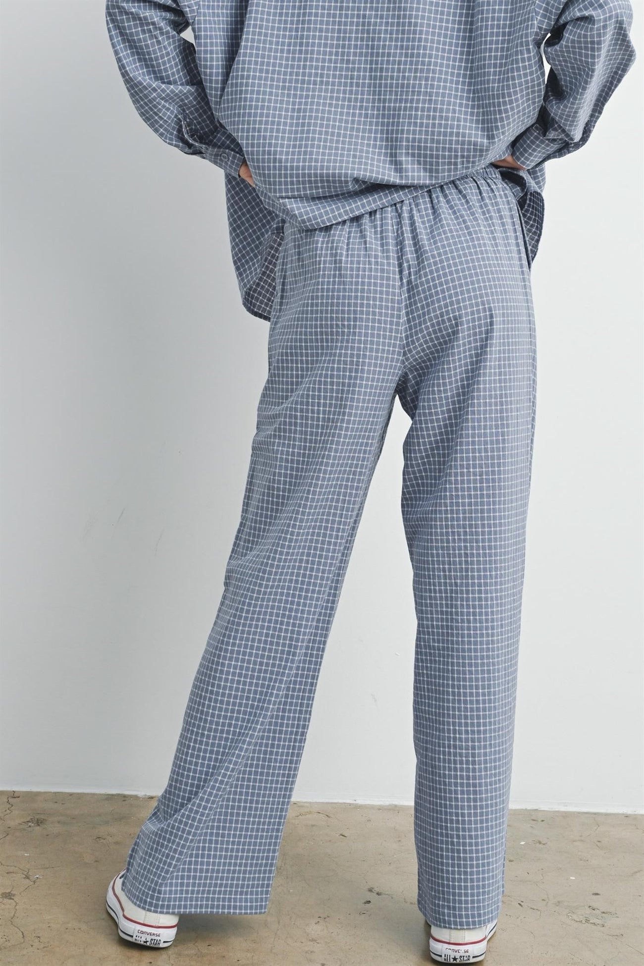 woman wearing blue and white checked loose-fitting pants with an elastic waistband from the back