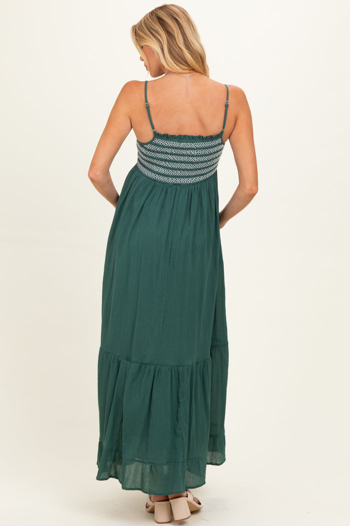 woman wearing a green maternity maxi dress with a smocked bodice and tiered skirt from the back