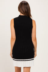 woman wearing a sleeveless black ribbed maternity dress with a white striped hem and a fitted silhouette
