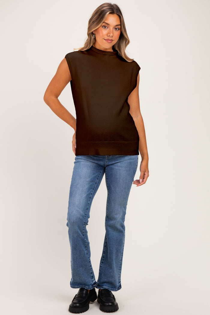 woman wearing a brown sleeveless maternity top and blue flared jeans