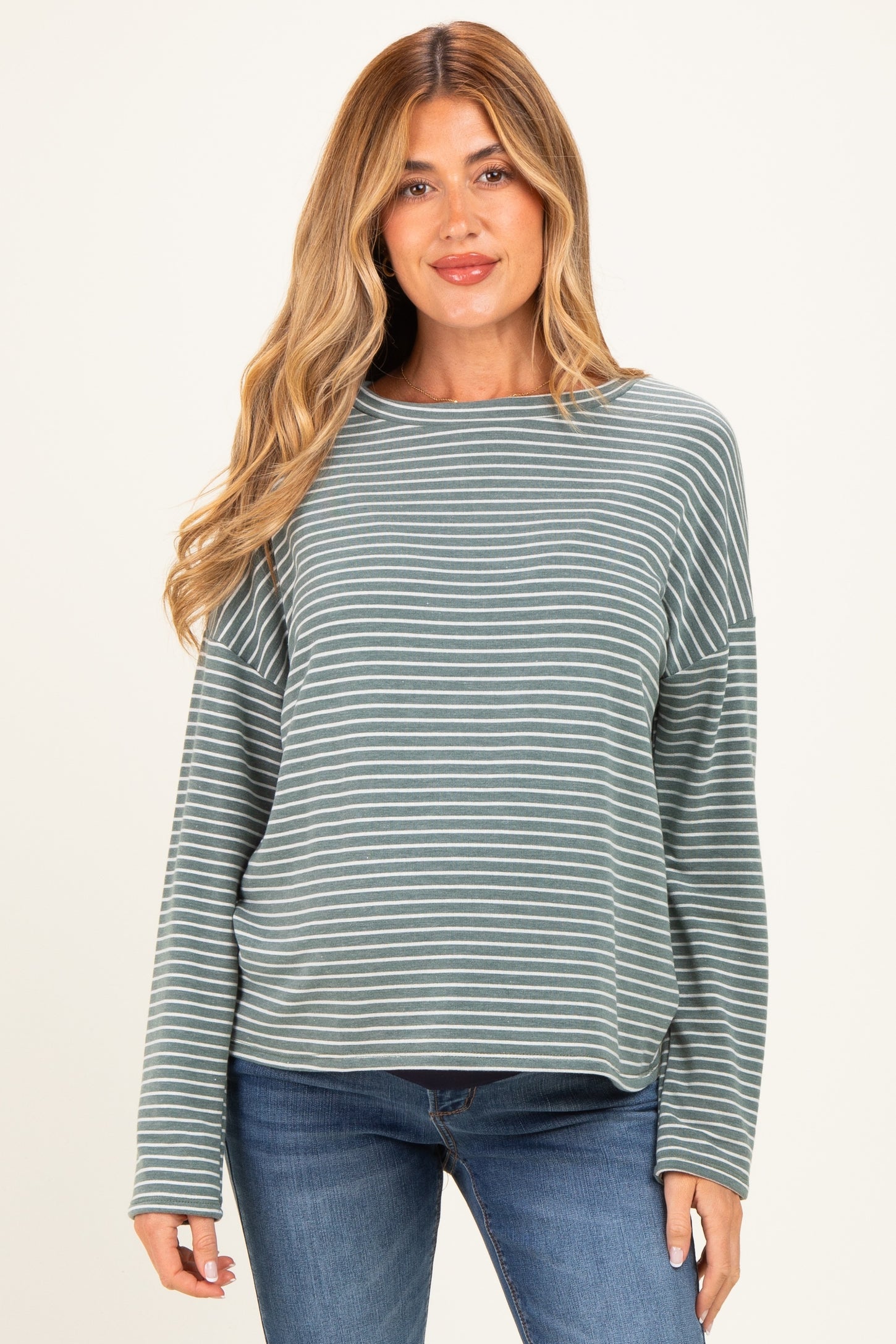 woman wearing a teal and white striped maternity top with long sleeves and relaxed fit