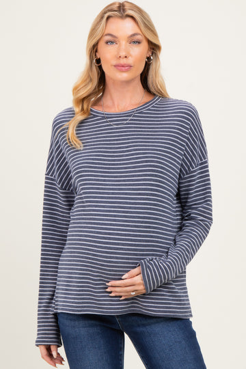 woman wearing a navy and white striped maternity top and showing her baby bump