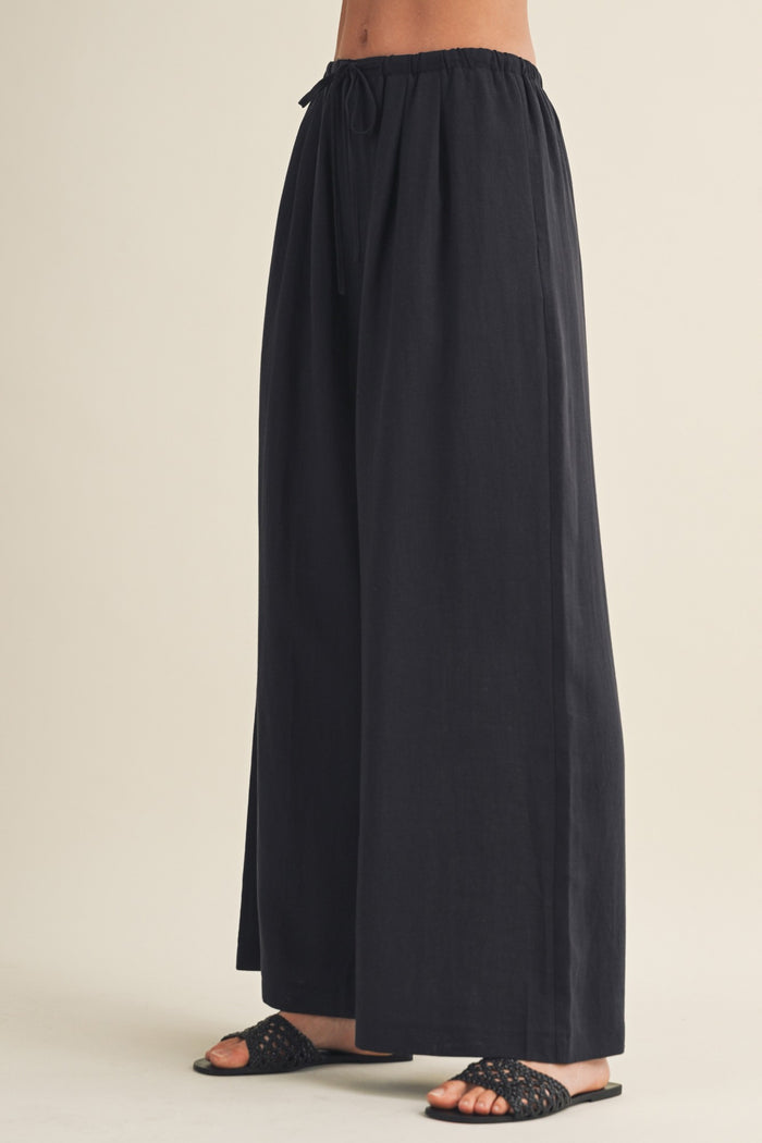 woman wearing black wide-leg pants with an elastic waistband and drawstring detail