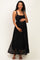 woman wearing a black lace maternity maxi dress and holding her baby bump