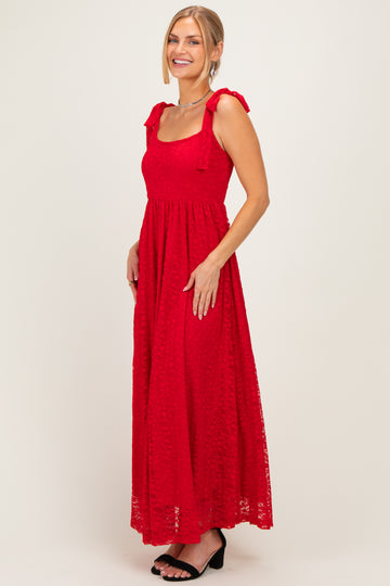 woman wearing a red maxi dress with bow-tie shoulder straps and a fitted bodice