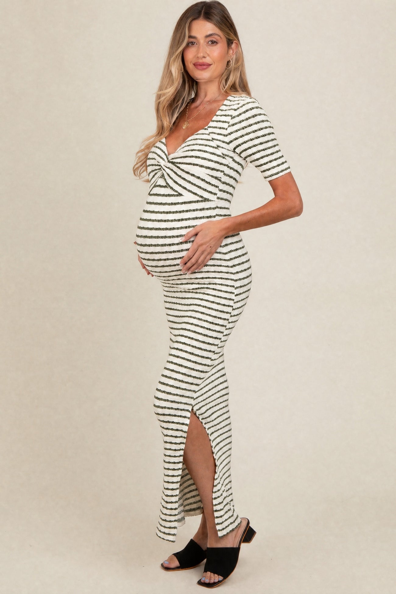 woman wearing a striped maternity dress with a knot detail and side slit, highlighting her baby bump