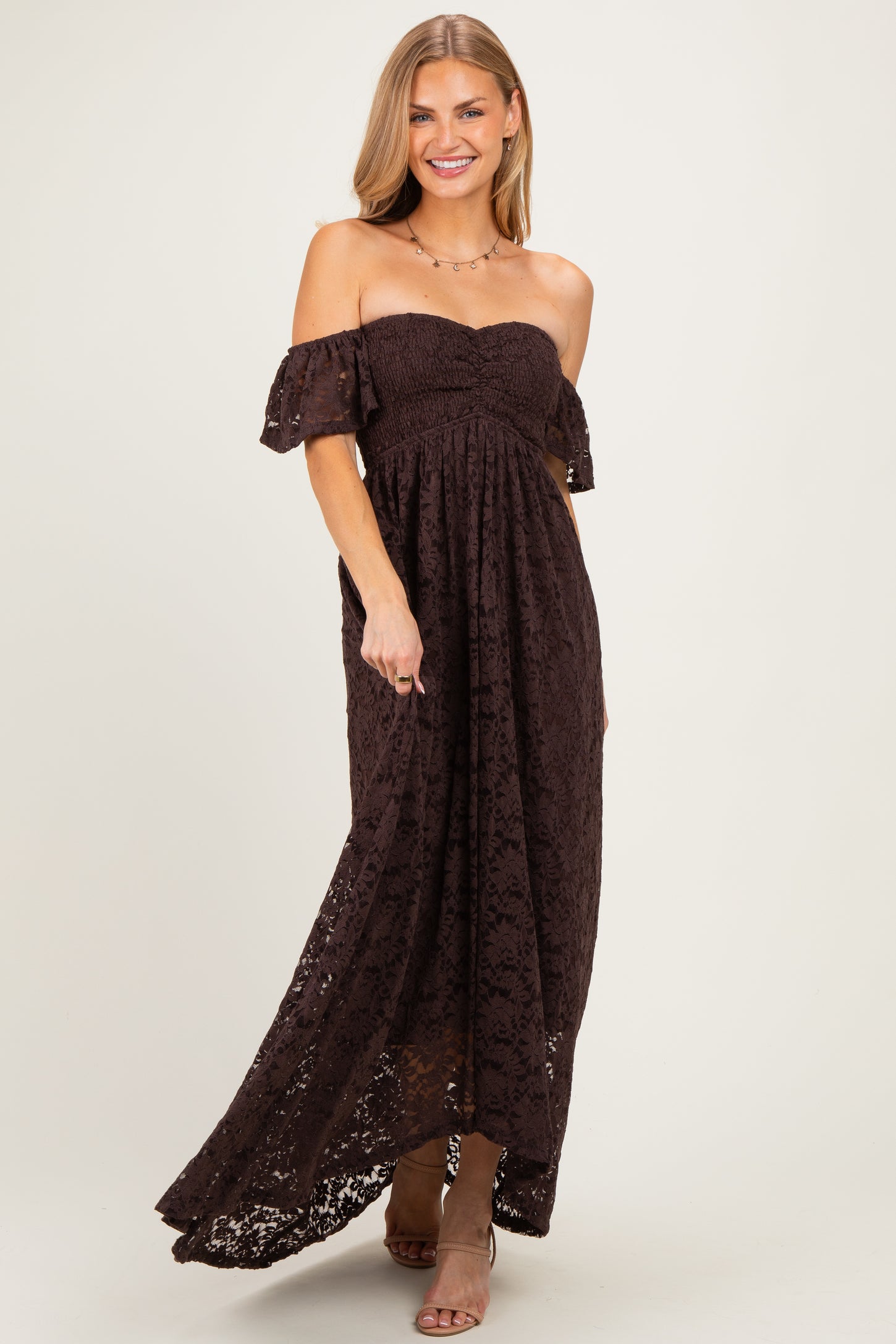 woman wearing a dark brown off-the-shoulder lace maxi dress with flowing sleeves