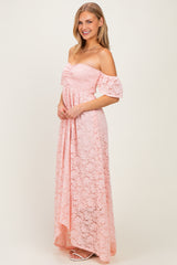 woman wearing a light pink off-shoulder lace maxi dress with flared sleeves