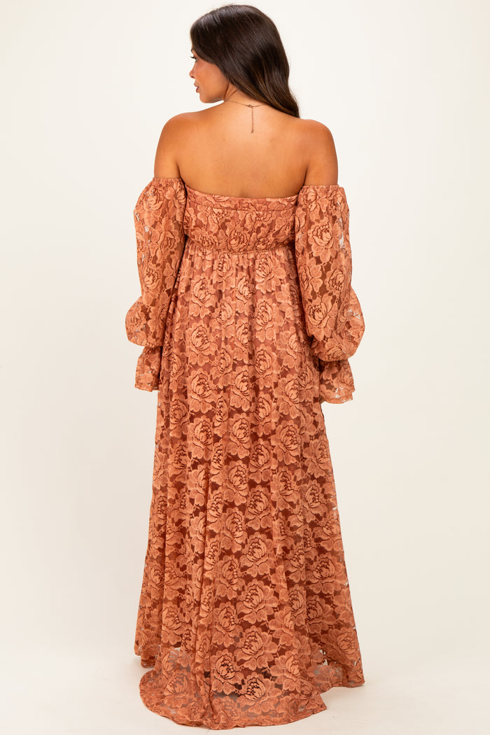 woman wearing a rust-colored off-the-shoulder lace maternity maxi dress with long puff sleeves