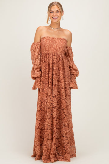 woman wearing a rust off-the-shoulder maxi dress with bell sleeves and floral lace details