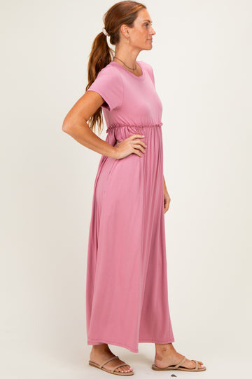 woman wearing a rose pink short sleeve maxi dress with a cinched waist and flowy skirt, standing sideways