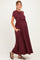 woman wearing a burgundy short sleeve maternity maxi dress with side pockets and an elastic waistband, showing her baby bump
