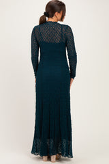 woman wearing a teal lace maternity maxi dress with long sleeves, showing a form-fitting silhouette and flared hem