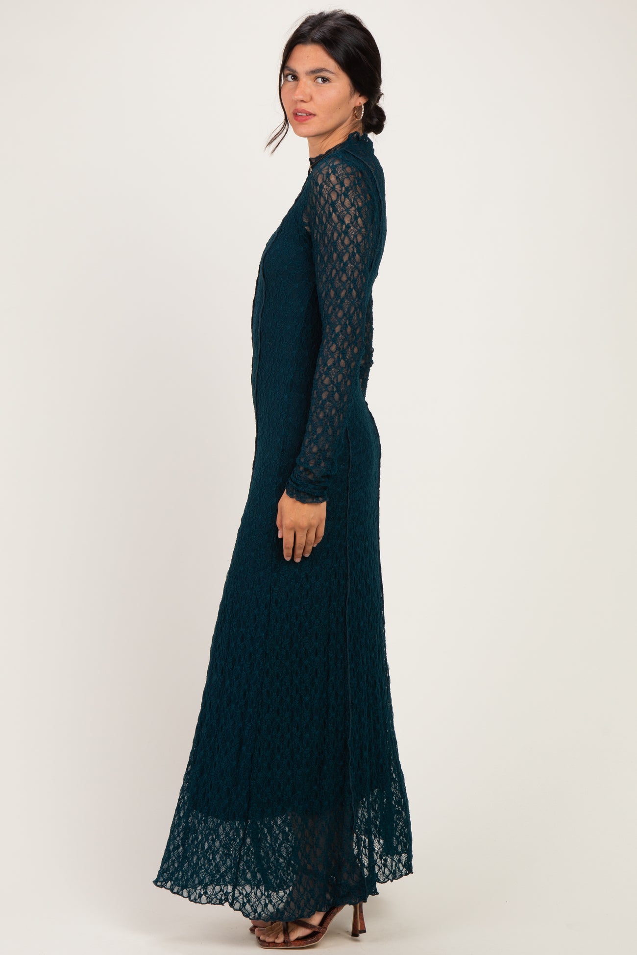 woman wearing a dark teal long sleeve lace maxi dress with a fitted bodice and flared skirt