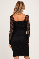 woman wearing a black lace long sleeve maternity dress, showing a fitted silhouette and ruched detail