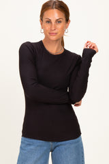 woman wearing a black ribbed long sleeve fitted top with slight shoulder detailing and blue jeans