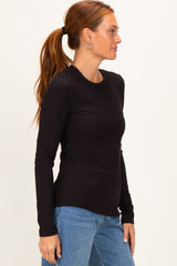 woman wearing a black long sleeve ribbed top with round neckline and side profile view
