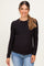 woman wearing a black long sleeve maternity top and smiling with her baby bump visible