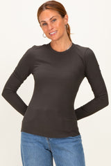 woman wearing a dark gray long sleeve ribbed top with a round neckline and casual jeans