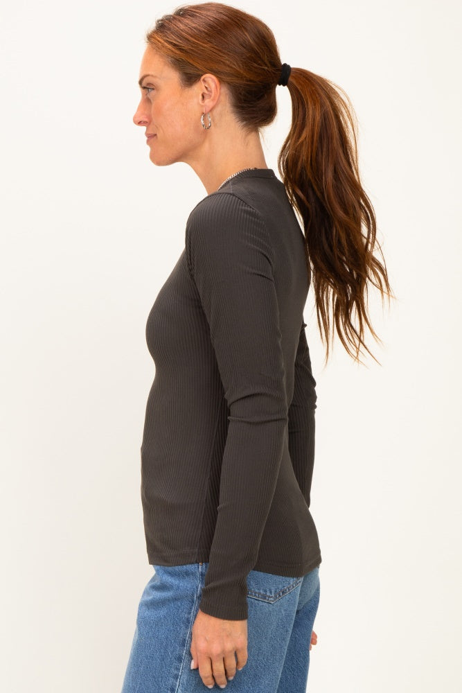 woman wearing a dark gray ribbed long sleeve top styled with fitted jeans