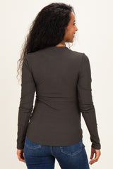 woman wearing a dark grey long sleeve ribbed maternity top, showing the back view