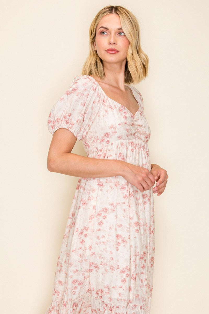 woman wearing a white floral maxi dress with puff sleeves and a square neckline