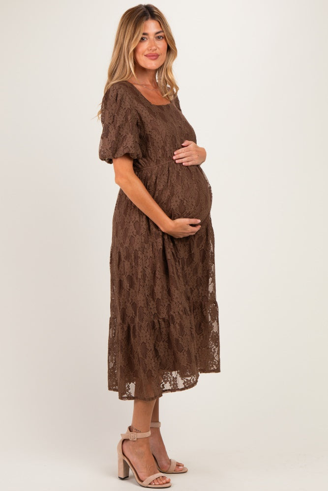 woman wearing a brown lace maternity dress with short sleeves and a visible baby bump
