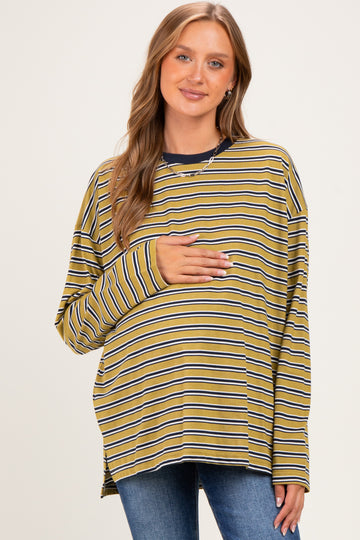 woman wearing a yellow and navy striped maternity top and holding her baby bump