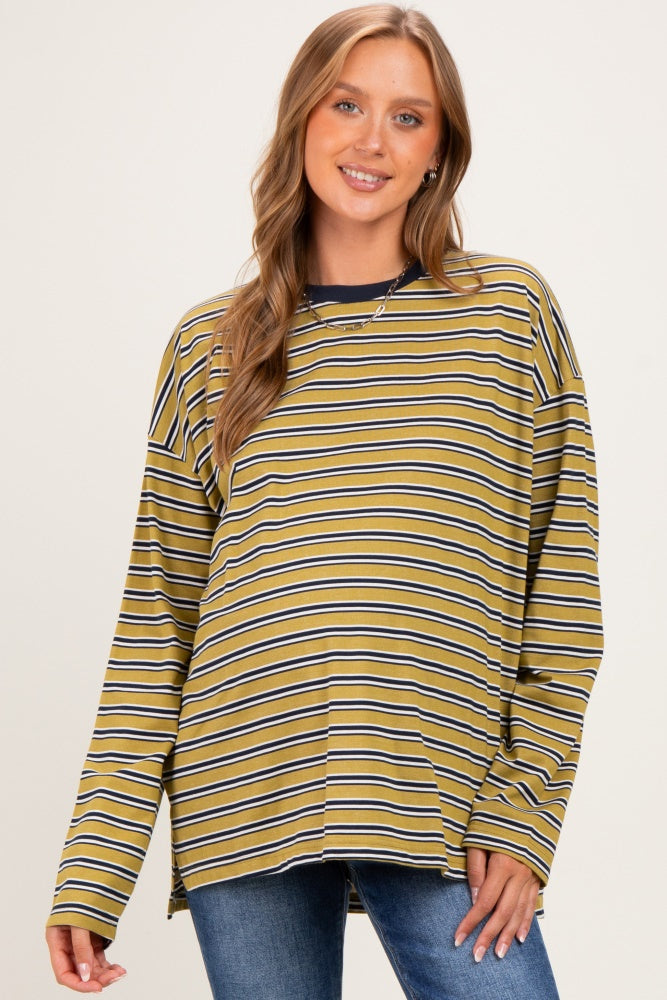 woman wearing a mustard striped maternity top with long sleeves, smiling and showing her baby bump