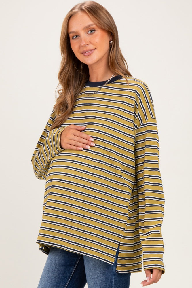 woman wearing a mustard yellow and navy striped maternity top and holding her baby bump