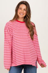 woman wearing a pink and red striped oversized maternity top with long sleeves and a relaxed fit