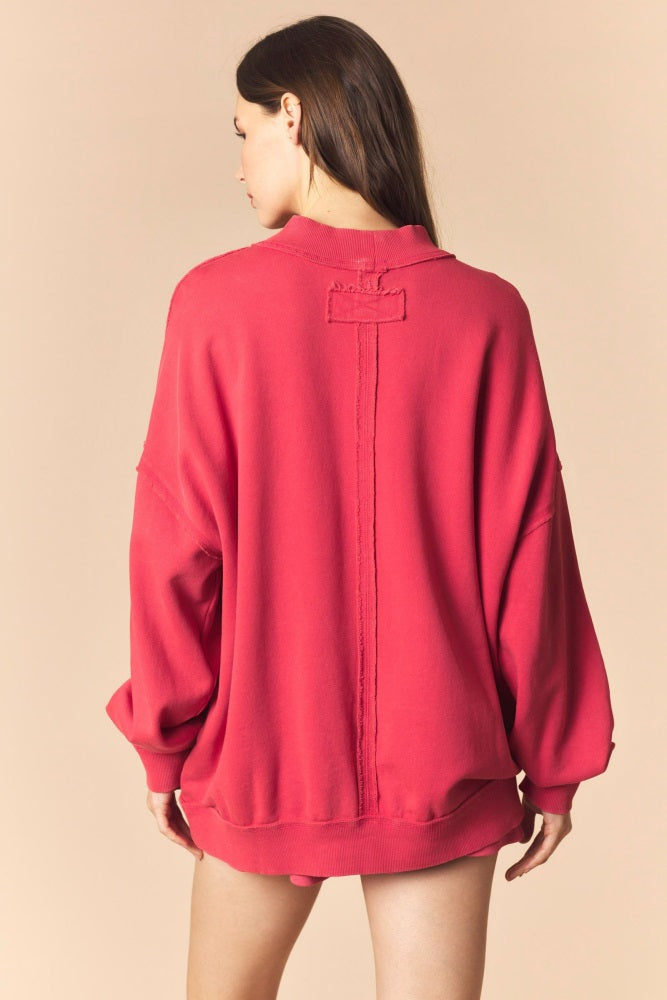 woman wearing a pink oversized sweatshirt with a relaxed fit and back detail