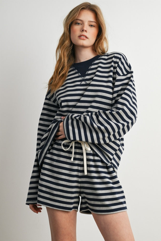 woman wearing a navy and white striped oversized pullover and matching shorts