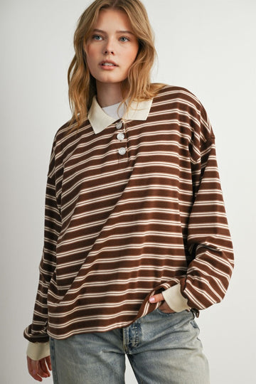 woman wearing a brown and cream striped long sleeve polo top with buttons and relaxed fit, paired with light blue jeans