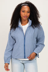 woman wearing a blue and white checkered zip-up jacket and light blue jeans