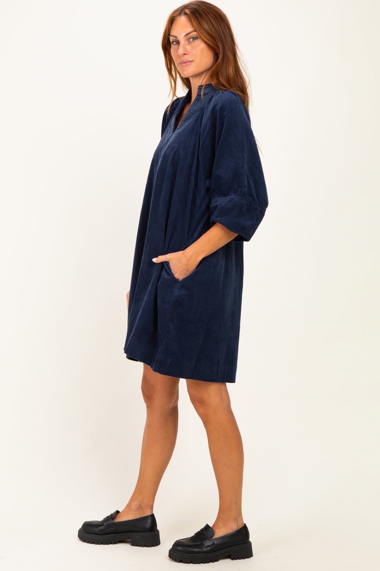woman wearing a navy blue oversized dress with elbow-length sleeves and side pockets