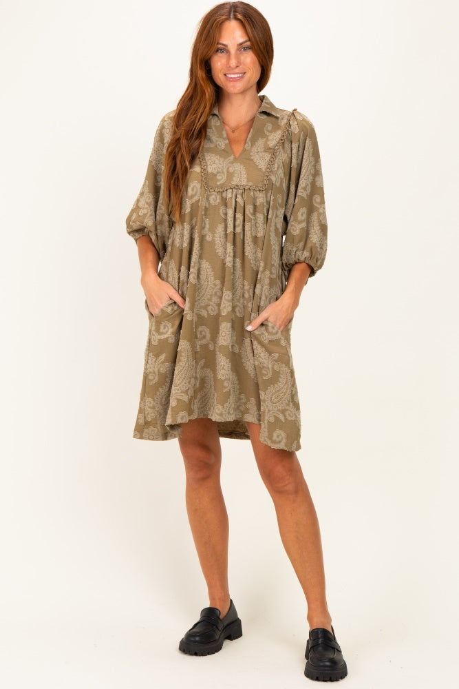 woman wearing a khaki paisley print short dress with puff sleeves and side pockets