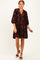 woman wearing a dark brown floral print short sleeve dress with a v-neckline and a loose fit
