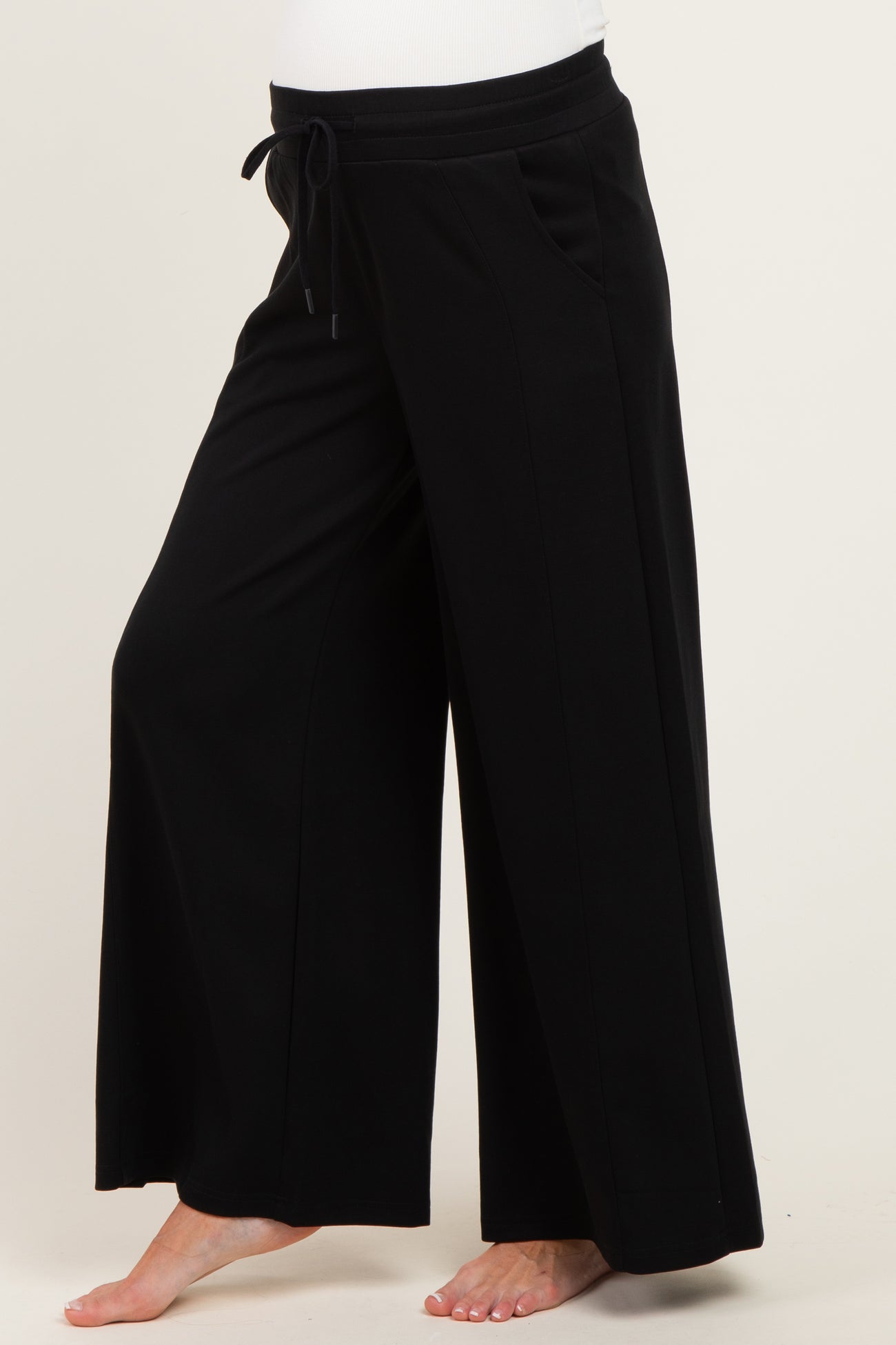 woman wearing black wide-leg maternity pants with an elastic waistband and drawstring detail